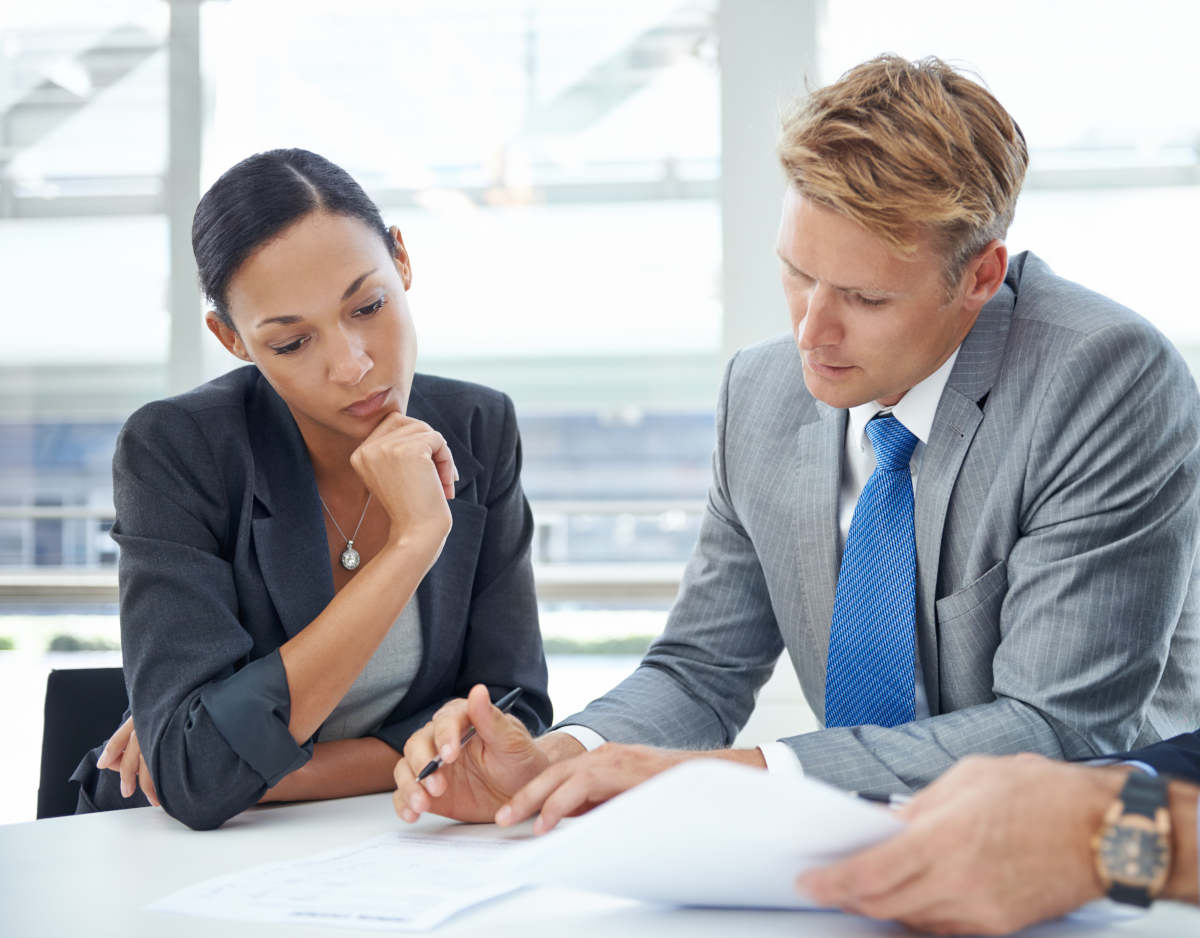 Reviewing their assets and liabilities. Shot of businesspeople looking over documents