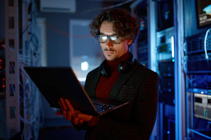 IT technician checking the servers vitals using laptop computer.