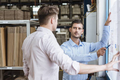 Product manager che argomenta con un ingegnere la linea produttiva